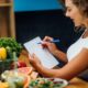 women with notepad surrounded by healthy foods